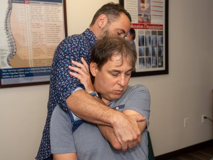 Dr. Esposito performing a standing adjustment on a patient.