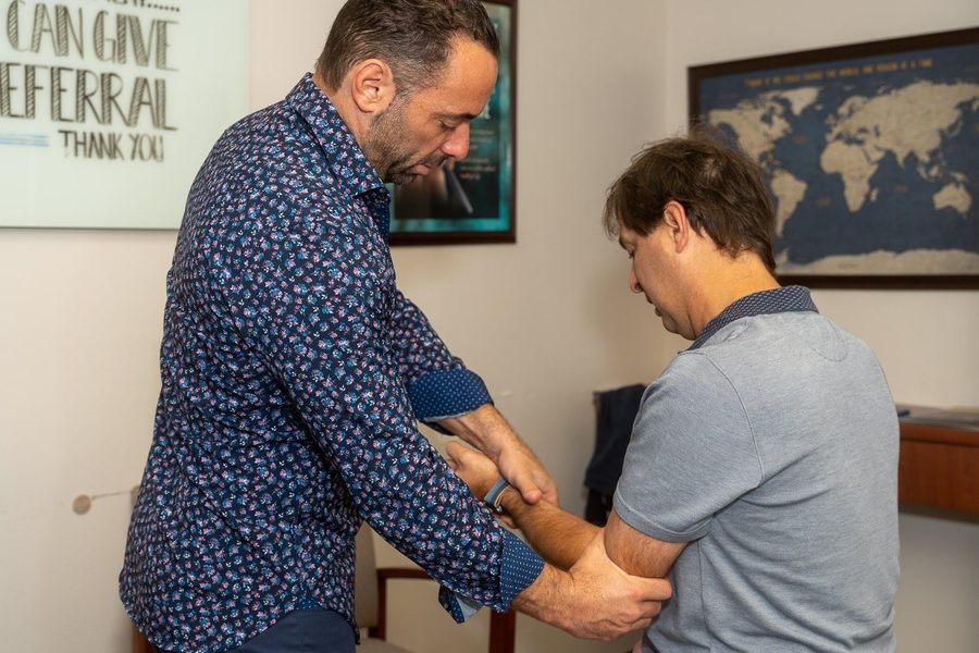 Dr. Esposito performing an arm and wrist mobility check on a patient.