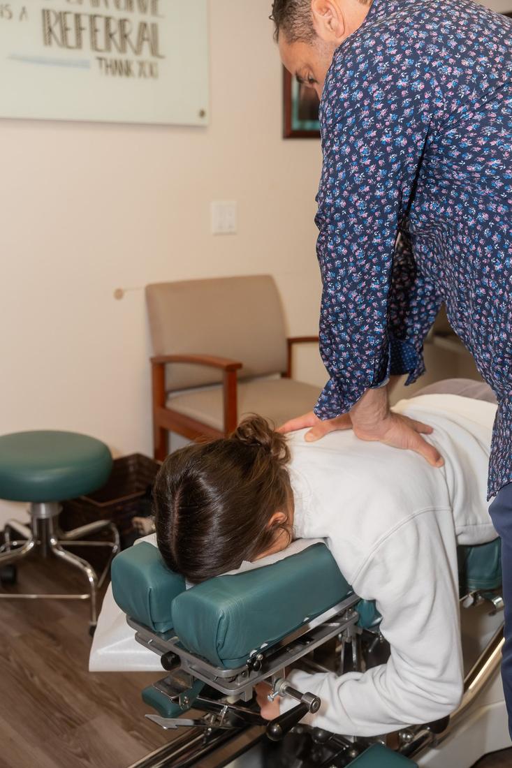 Dr. Edward Esposito pressing both hands on a patient's back during a treatment.