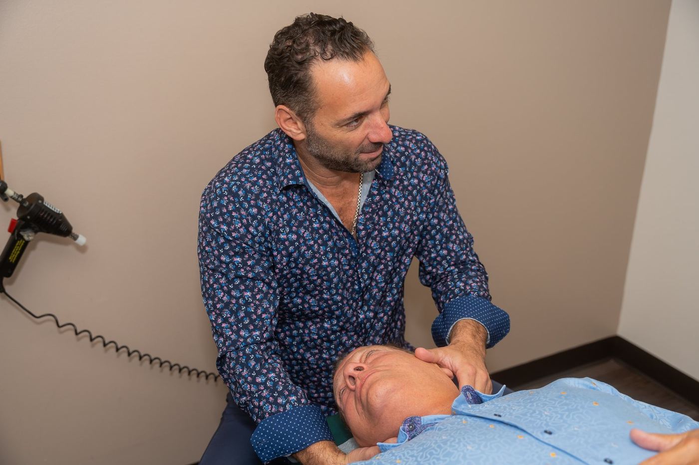 Dr. Edward Esposito pausing during a patient's arm and shoulder stretch.