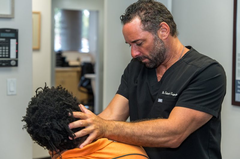 Dr. Esposito performing a cervical adjustment on a patient.