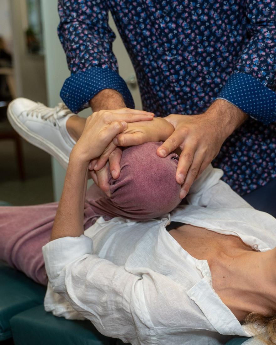 Dr. Edward Esposito's hands cradling a patient's head during a cervical technique.