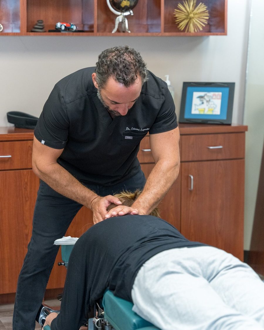 Dr. Edward Esposito performing a cervical adjustment on a patient at Miami Chiropractic.