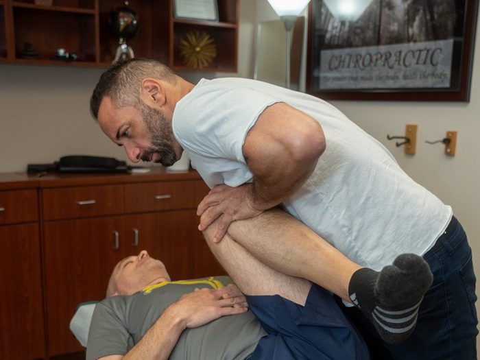 Dr. Edward Esposito assessing an athletic patient's hip and leg mobility.